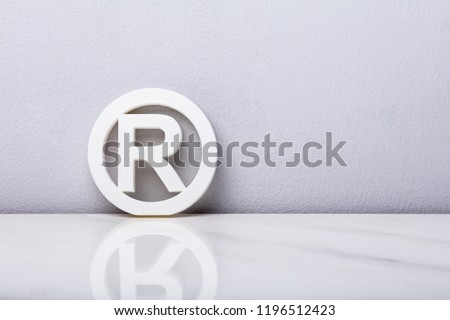 White Registered Trademark Sign Leaning On Wall