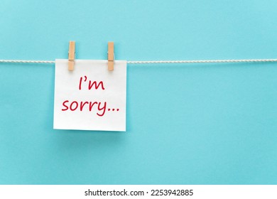 White reminder paper on a rope with a clothespin with a motivational inscription I'm sorry in handwritten font on a colored background with free space for text - Shutterstock ID 2253942885