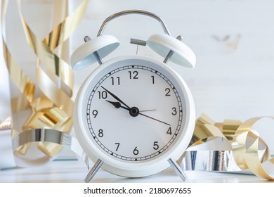 White Retro Alarm Clock On A White Background With Gold Party Streamers