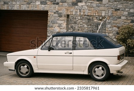 White Retro Cabriolet, an Iconic 80s European Convertible, Graces the Open Road. Retro cabriolet. Convertible vehicle. White 80s European compact convertible hatchback car. Timeless Elegance