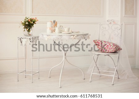 white retro iron furniture with coffee set on the table and pillow on chair