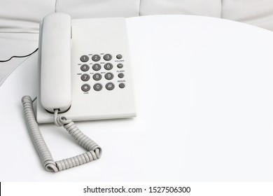 White Retro Landline Phone On A Wooden White Round Table. White Push Button Phone In Interior