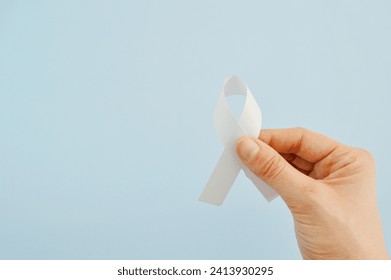 White ribbon as a symbol of peace on a blue background. World Day of Peace. International Day Of Human Fraternity. International Day of Living Together in Peace. International Human Solidarity Day - Powered by Shutterstock