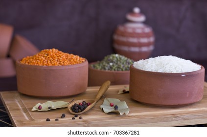 White rice, red lentils and green peas mache on a wooden tray. Bay leaves and black peppercorns in wood spoon. - Powered by Shutterstock