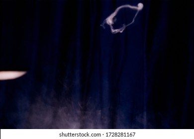 White Ring Of Smoke On A Black Fabric Background. Smoke Spreads Over The Background. Vape Culture. Conceptual Image.