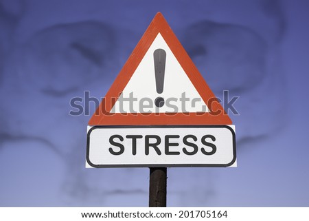 White road warning triangle with black  exclamation point and red frame on  a wooden mast in front of a blue sky. A second rectangular sign warns in english about stress