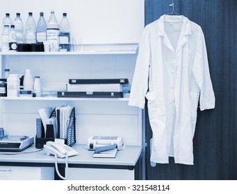 white robe hanging on a door in laboratory, blue toning