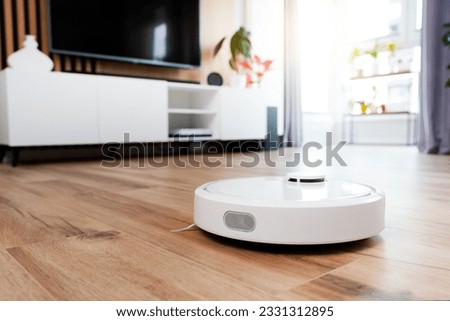 White robot vaccum cleaner on the floor in the living room, smart home device