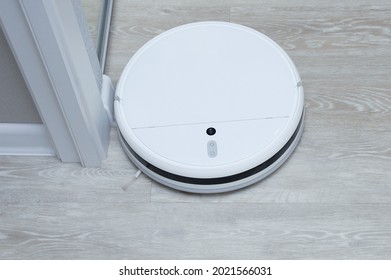 A White Robot Vacuum Cleaner Washes The Floor In A Room. View From Above.