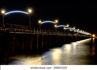 White rock pier at night with reflections on the ocean
