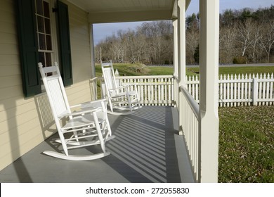 White Rocking Chairs on Front Porch with Picket Fence