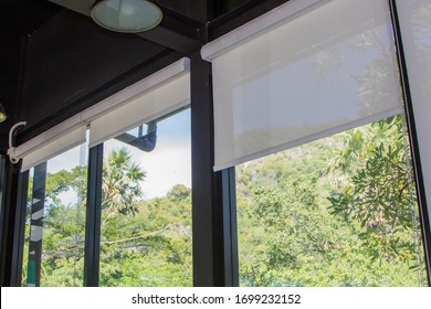 white roller blinds or curtains at the glass window