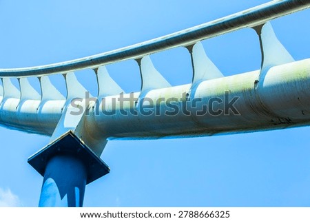 White Roller Coaster Track with Blue Steel Supports under Blue Sky