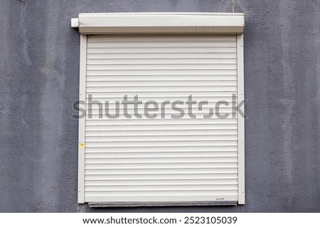 A white roller shutter is currently positioned on a gray wall, creating a noticeable contrast that enhances the overall aesthetic of the space