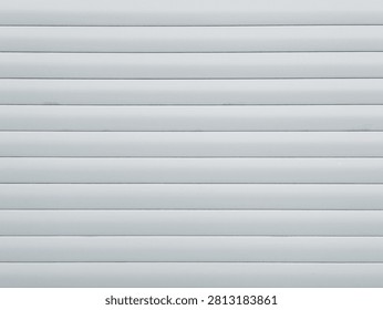White roller shutter texture background. Clean plastic or metal window blinds surface. Horizontal security shutter or garage door pattern.