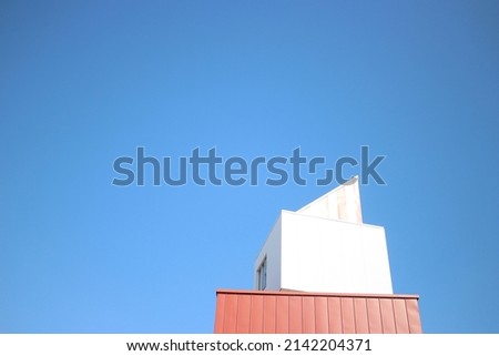 White roof of a building against blue. Minimalist image with space for runaround or wraparound text 
