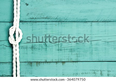 White rope with knot on blank antique mint green rustic wood background; sign with painted green copy space