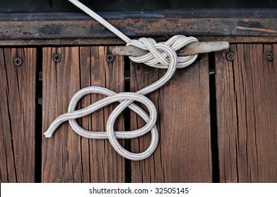  White Rope Securing Boat To Wooded Dock