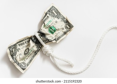 White rope tangled around a crumpled one dollar bill. Concept of money fraud, debt or credit payments.