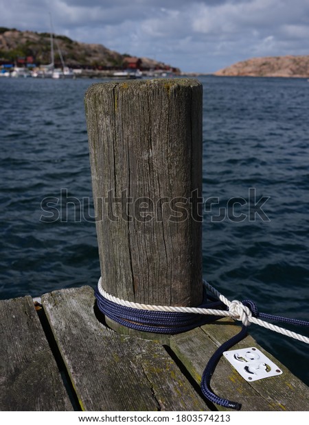 White rope tied to\
a wooden pole on a bridge