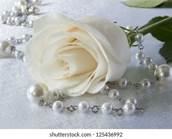 White Rose And Beads On White Background