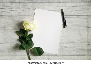 White Rose, Black Pen And Empty Paper Sheet On Rustic Table Shot From Above. Top View, Flat Lay, Copy Space.