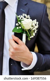 white rose boutonniere on suit of the groom