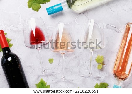 White, rose and red wine glasses and bottles. Flat lay