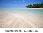 White and rose sand beach front of blue lagoon and tropical island