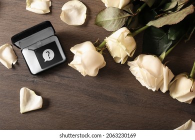 White Roses And A Gift. Waiting For A Marriage Proposal. A Box With A Question Mark. Earrings Or Ring?  Will You Marry Me? The Concept Of Creating A Family And Marriage. The Girl Wants To Get Married.