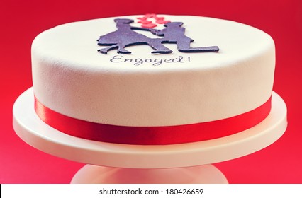 White Round Cake On Red Background, Decorated With Male And Female Silhouette Of Sugar On Top. 