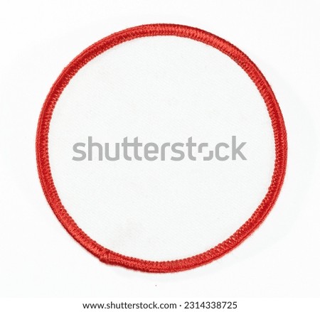 White round patch with red trim.