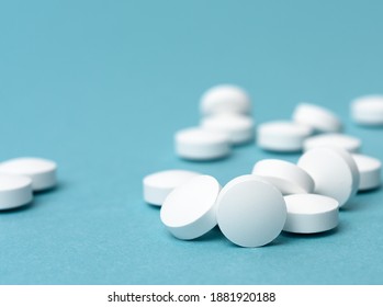 White round pill for healthcare. Medical treatment, bue background, close up