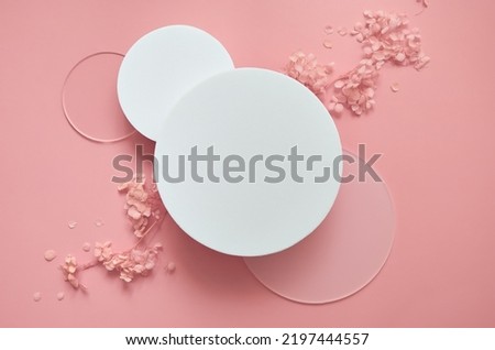White round podium pedestal cosmetic beauty product presentation scene empty mockup on trendy pink coral pastel background with spring flowers, minimalist flat lay backdrop luxury template, top view.