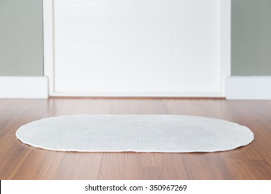 White Rug On Wood Floor In Front Of The Restroom.