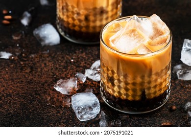 White russian cocktail, trendy alcoholic drink with vodka, coffee liqueur, cream and ice, dark background, bar tools