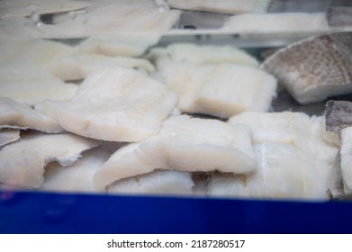White salted and dried bacalao codfish in watertank, traditional Spanish preserved seafood on display in fish shop