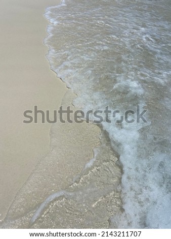 White sand and clear water on a sandbank on the Maldives in the Indian Ocean closeup wave