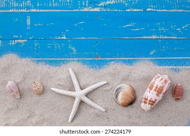 White Sand Star Fish And Shells On Blue Wooden Background