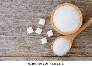 White Sand Sugar In Wooden Bowl And Wooden Spoon And Cube Sugar On Wood Table Background. Top View. Flat Lay.