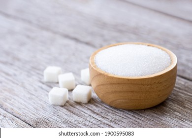 White Sand Sugar In Wooden Bowl  And Cube Sugar On Wood Table Background. 