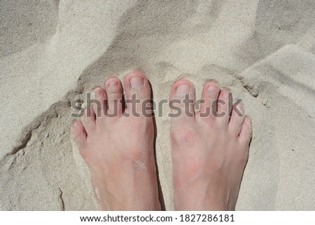 White sand texture female legs. white legs without shoes on the hot white sand. Bare feet of a girl on the beach. Smooth sunny sandy beach