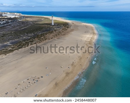 White sandy beach and blue ocean water in Morro Jable vacation village on south of Fuerteventura, Canary islands, Spain in winter