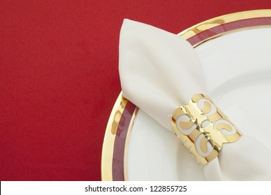 White Satin Napkin With Golden Ring On A Plate