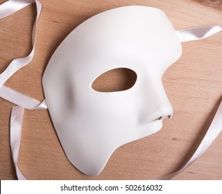White Scary Halloween mask on wooden background.