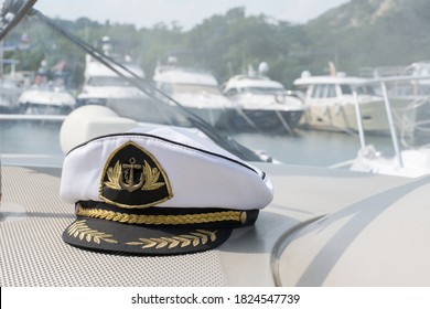 White sea captain's cap on the dashboard of the boat