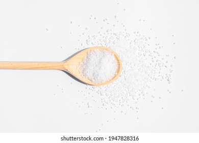White sea salt on wooden spoon. Isolated on white background. Rustic appearance. High quality photo