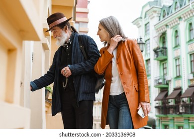 White Senior Couple Opening Door While Standing, Outdoors