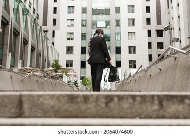 White Senior Man With Leather Backpack Going Up City Stairs Outdoors