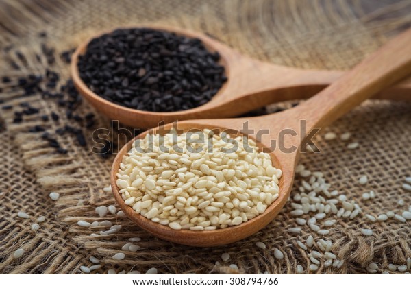 White sesame\
and black sesame seed on wooden\
spoon